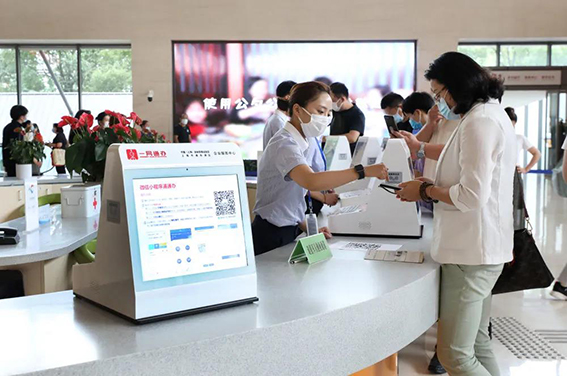 wx在上海市浦东新区企业服务中心办事大厅，工作人员指导市民通过手机小程序办理一网通办业务（2020年8月4日摄）。.jpg